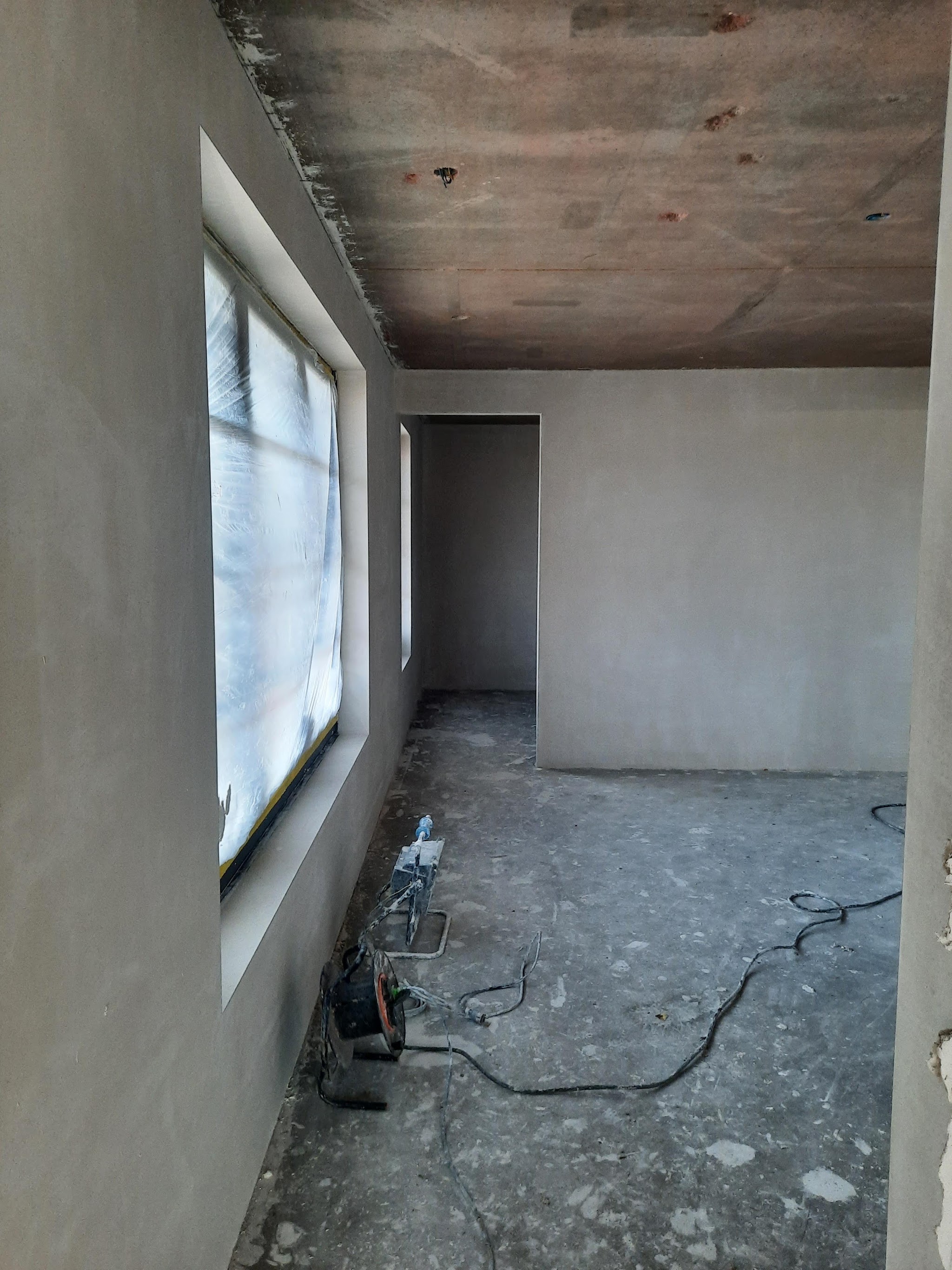 Kamer in verbouwing met vers gestucte wanden