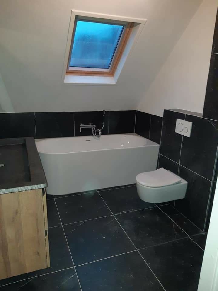 Afgewerkte badkamer met een schuin gestuct plafond